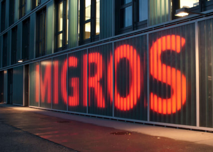 Migros Waadt Aussenmauer mit Logo